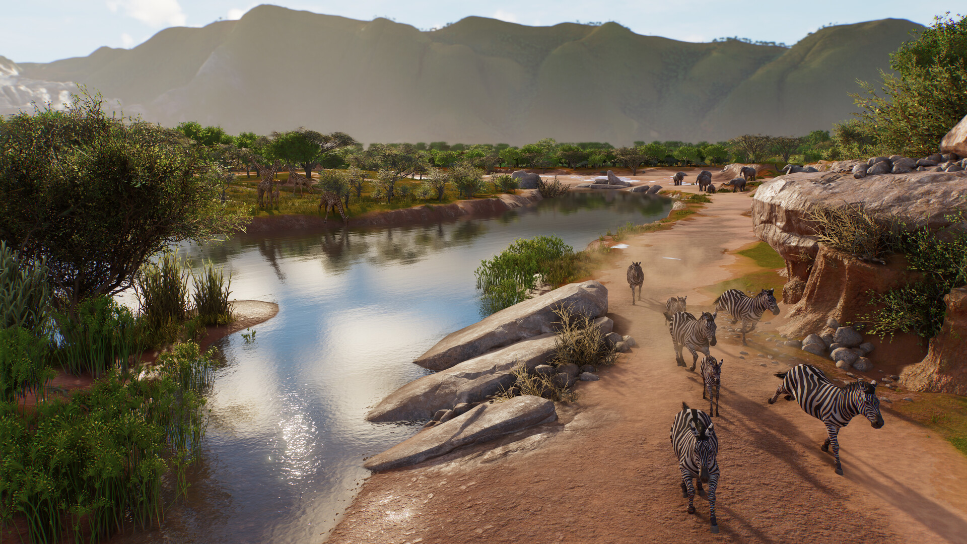 Official Planet Zoo 2 screenshot of a large zoo area with water, paths and groups of animals